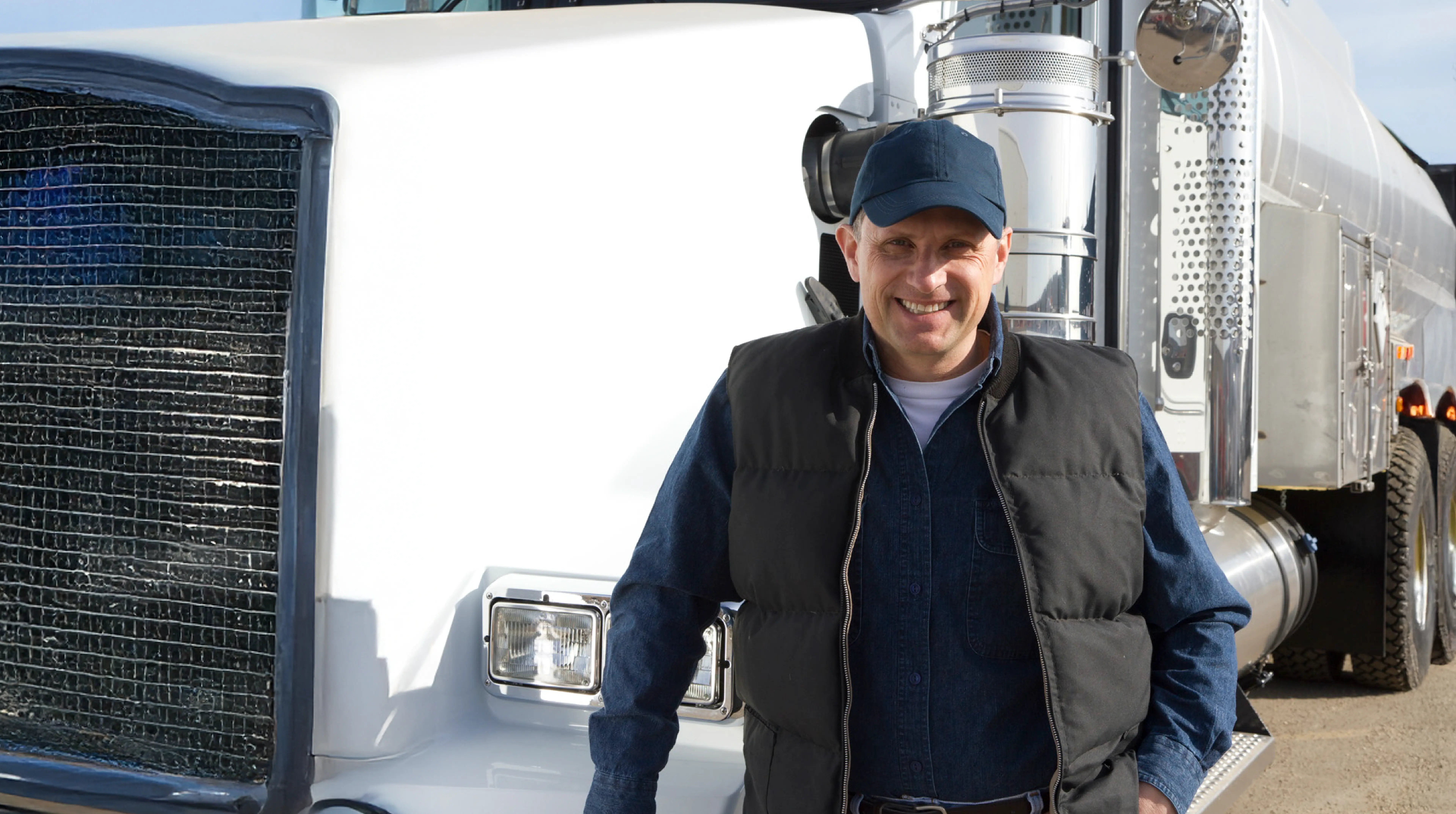 Smiling Transport ATD driver standing beside a white truck.
