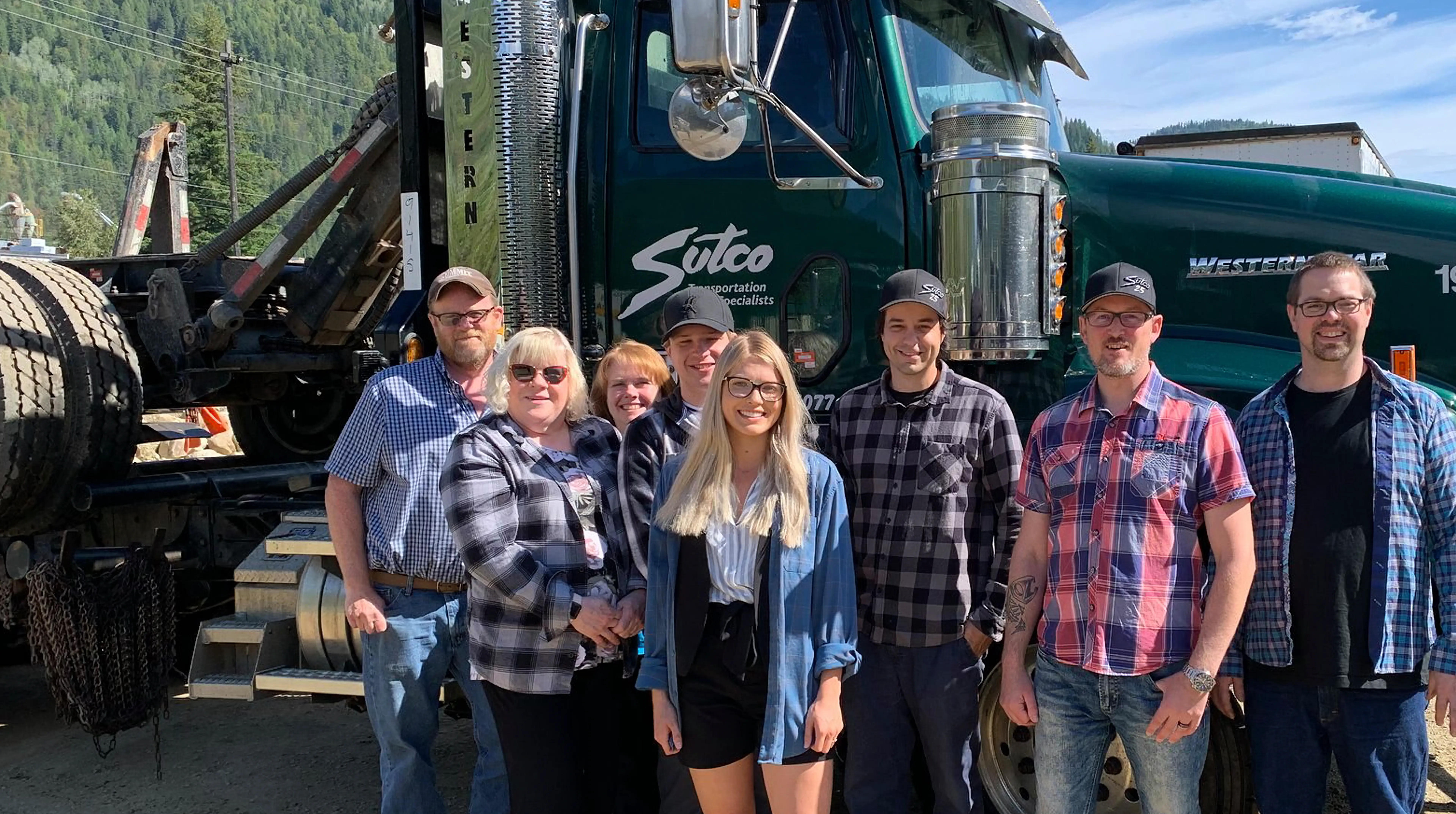 Sutco Transportation team standing in front of a green Western Star truck.