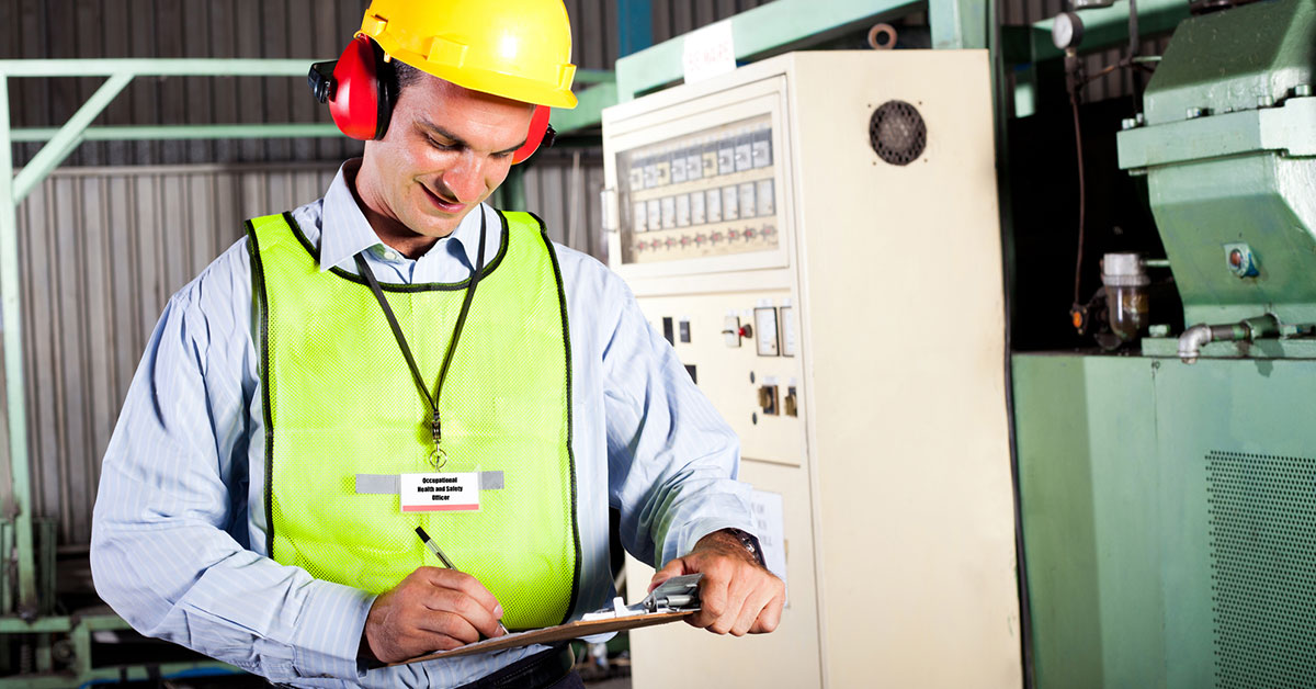 Smiling worker wearing a hard hat, safety vest, and ear protection to demonstrate proper safety and employee satisfaction on a job site.