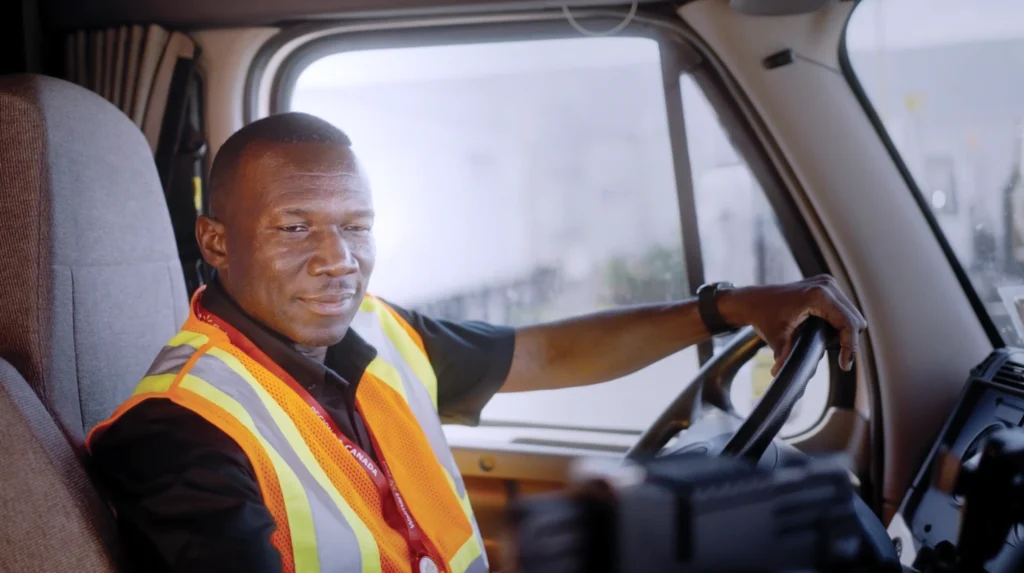 Walmart truck driver in a safety vest driving with focus and professionalism.