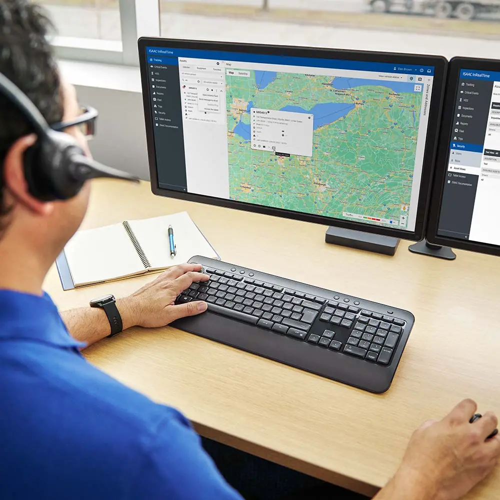 Fleet dispatcher monitoring trucks via ISAAC platform on dual monitors