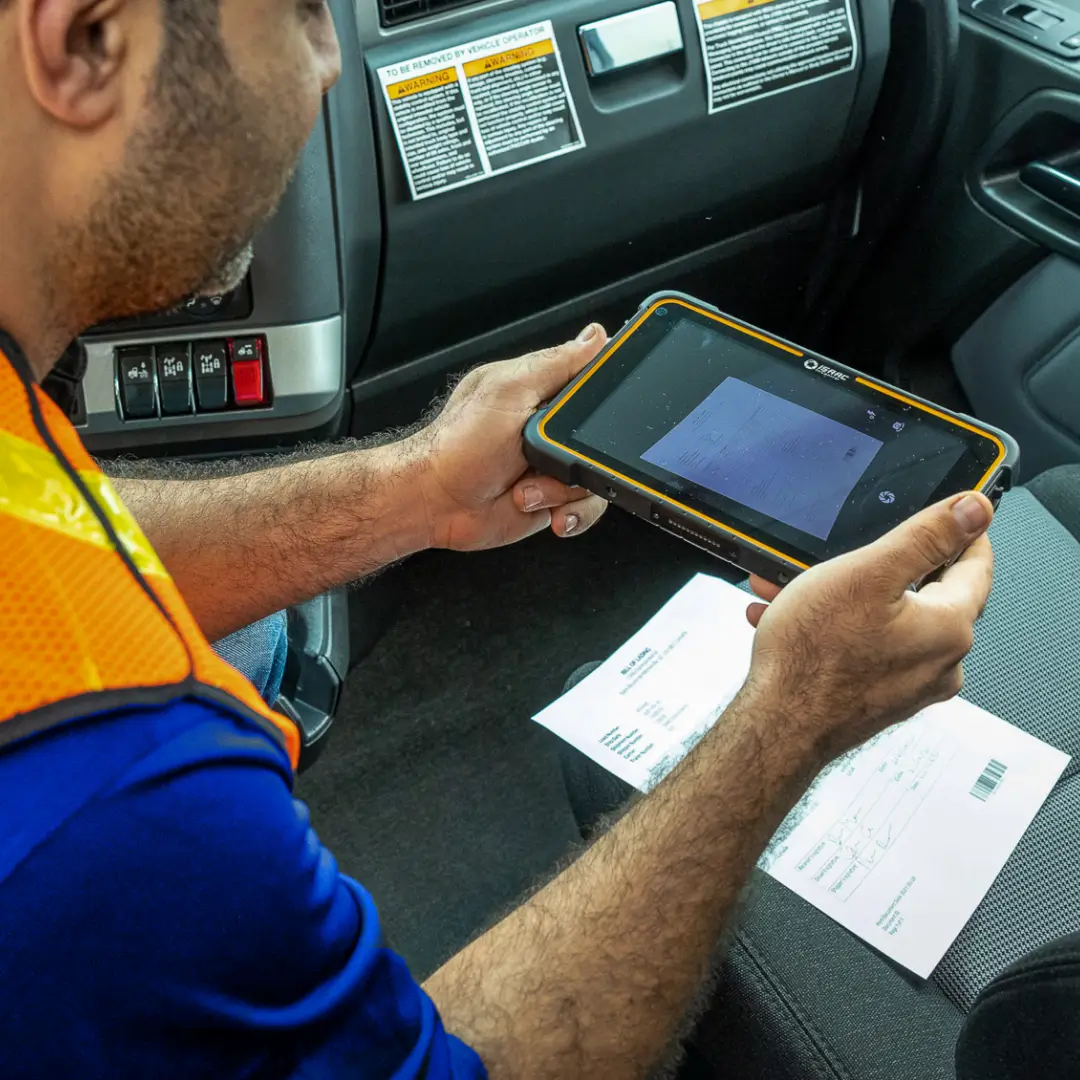 Document Management for Truck Drivers Truck driver scanning documents on a tablet inside the truck.