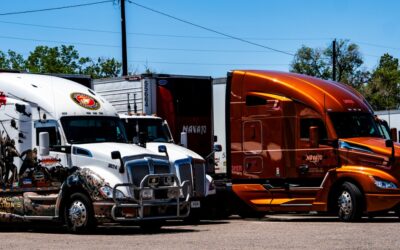 Two Navajo Express trucks, one wrapped in a military tribute honoring veterans, showcasing the fleet's partnership with ISAAC Instruments