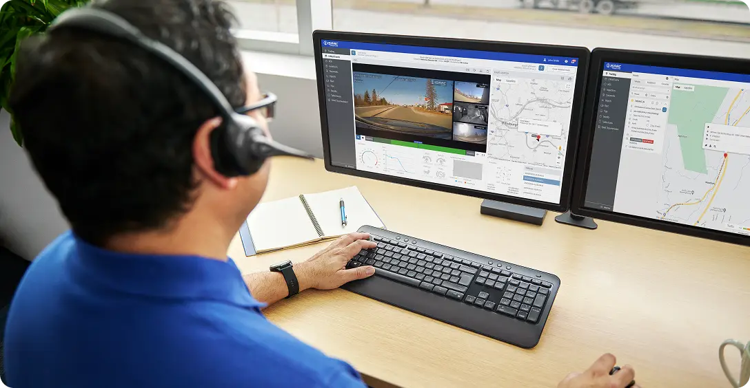 Monitoring Fleet Video and Data with ISAAC InView Portal Fleet manager reviewing ISAAC InView AI camera footage and telematics data on dual monitors