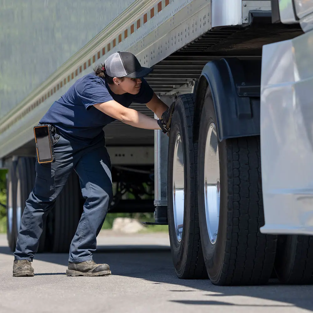 Wheel Retorquing Safety Check with ISAAC Maintenance technician inspecting truck wheels with ISAAC tablet on belt