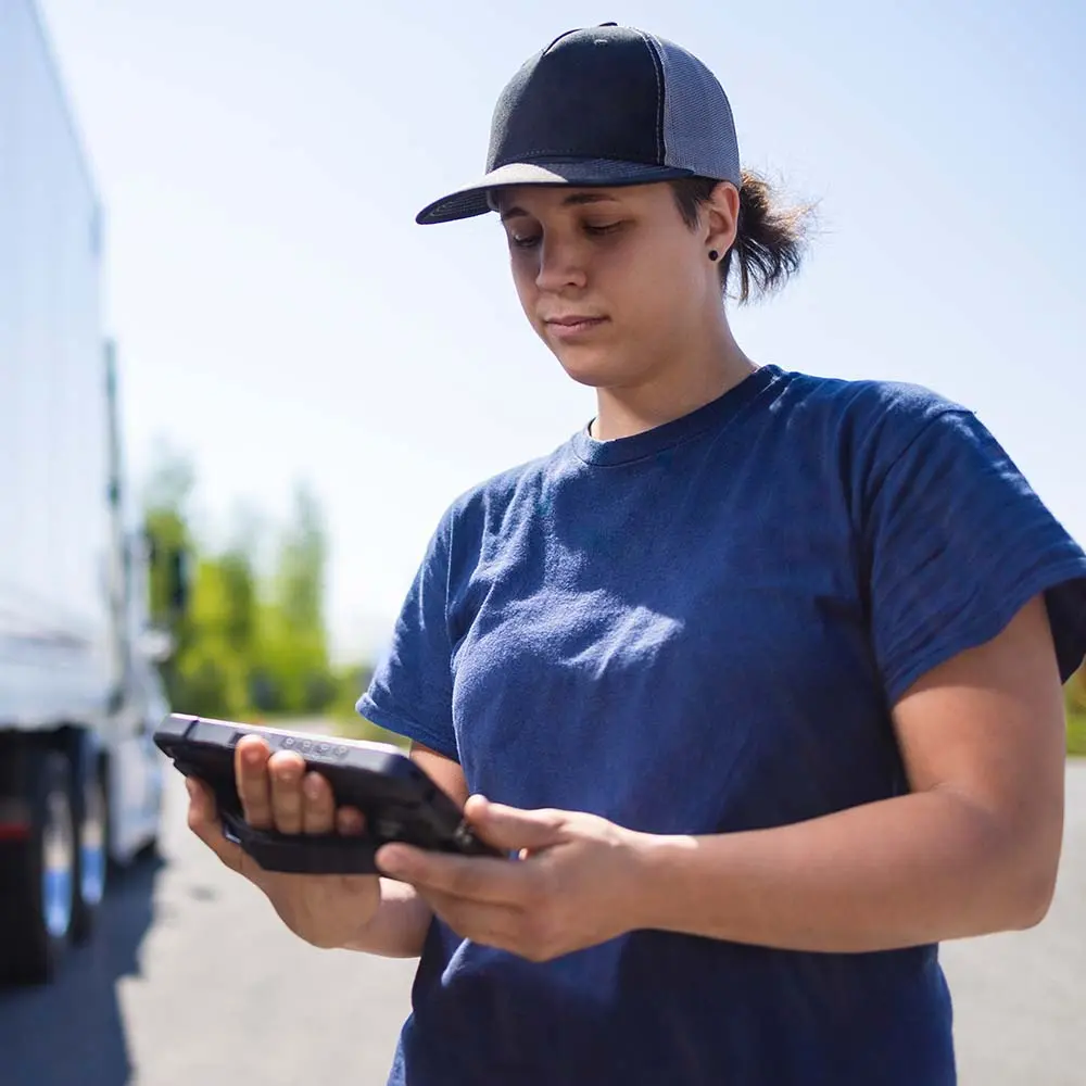 Reliable Fleet Tech in the Field Truck driver using rugged ISAAC tablet outside the vehicle