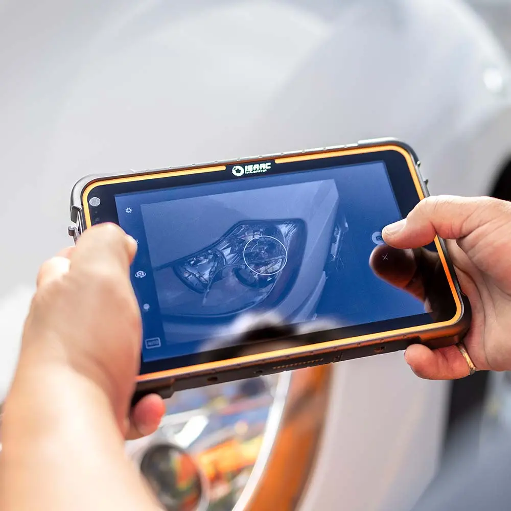 ISAAC Tablet Used for DVIR Inspection Technician using ISAAC tablet to photograph truck headlight during DVIR process