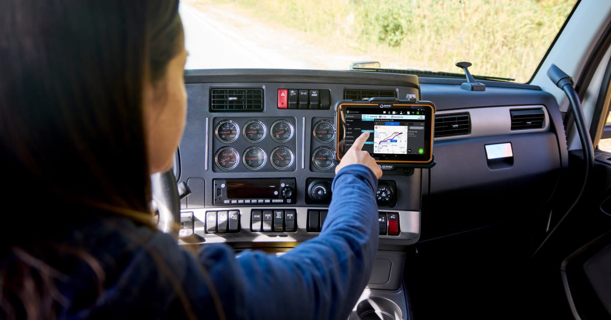 A commercial truck driver using the Trimble CoPilot navigation app on an ISAAC ELD tablet to view truck-legal routes and real-time guidance.