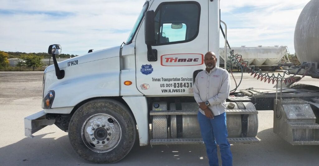 Trimac Transportation driver standing beside his truck, which displays an ISAAC decal